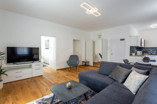 a living room with a blue couch and a tv at Vila Slovenka in Celje
