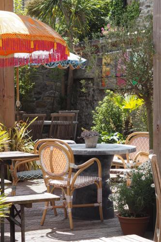 a table with chairs and an umbrella on a patio at Artist Residence Cornwall in Penzance