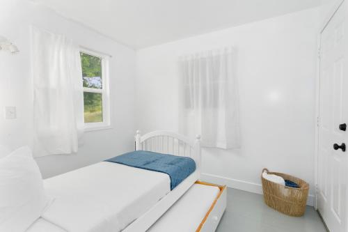 a white bedroom with a bed and a window at Breakwater Resort in Grayland