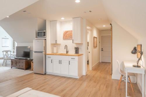 a kitchen with white cabinets and a table in a room at Scarlet Ridge Retreat - Near Wineries & DT Austin in Austin