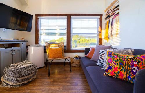 a living room with a blue couch with colorful pillows at Monte Mahala Casa Vega in Johnson City