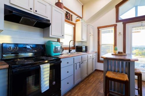 a kitchen with a black stove and white cabinets at Monte Mahala Casa Vega in Johnson City