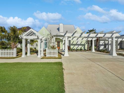 une maison blanche avec pergola blanche dans l'établissement Cottage at The Beach Club - Heated Private Pool & FREE ACTIVITIES, à Gulf Highlands