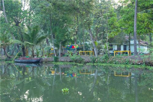 a body of water with a house and trees at Aqualillies Water Front Heritage Homestay in Kumarakom