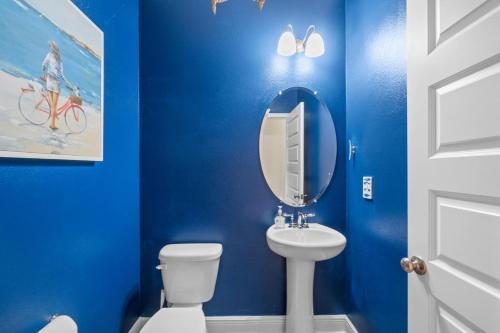 a blue bathroom with a white toilet and a mirror at Beach House - Redfish Cove at Windmark Beach by Panhandle Getaways in Port Saint Joe