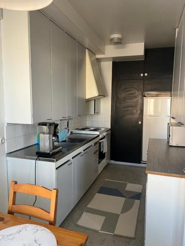 a kitchen with white cabinets and a stove top oven at Apartment Kopin3 in Kokkola