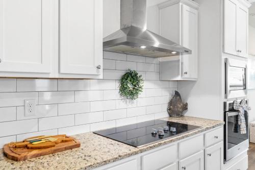 a kitchen with white cabinets and a stove top oven at Beach House - Redfish Cove at Windmark Beach by Panhandle Getaways in Port Saint Joe