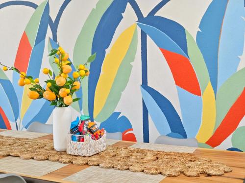 a table with a vase of oranges and flowers on it at Sageview Cottage - 4 BDR with Pool Pet Friendly in Houston