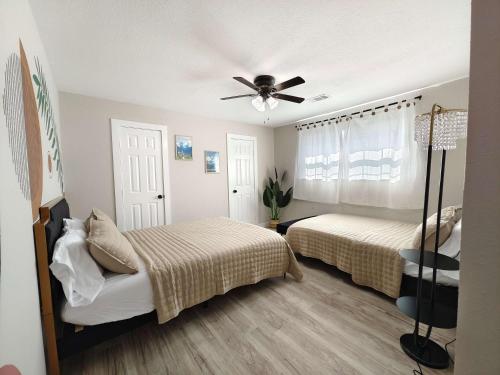 a bedroom with two beds and a ceiling fan at Sageview Cottage - 4 BDR with Pool Pet Friendly in Houston