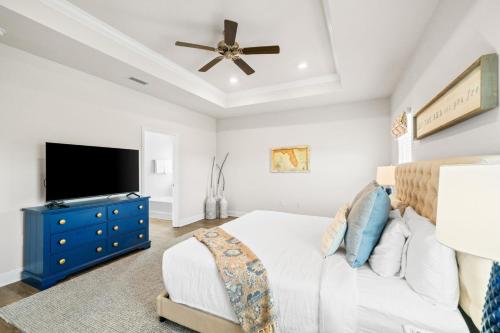 a bedroom with a bed with a blue dresser and a tv at Beach House - Redfish Cove at Windmark Beach by Panhandle Getaways in Port Saint Joe