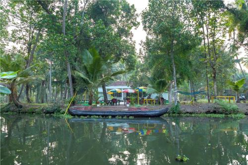 a small boat in the water with a playground at Aqualillies Water Front Heritage Homestay in Kumarakom