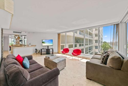 uma sala de estar com dois sofás e uma TV em Condo on the Pool - Retreat for 4 with Water Views & Resort-style Amenities em Miami