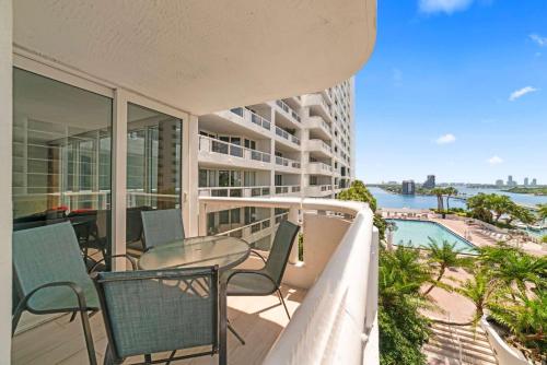uma varanda com mesa e cadeiras em um prédio em Condo on the Pool - Retreat for 4 with Water Views & Resort-style Amenities em Miami