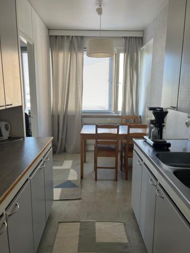 a kitchen with a table and a dining room at Apartment Kopin3 in Kokkola