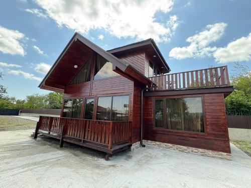 a small wooden house with a balcony on top at Woodland Tskaltubo in Tskaltubo