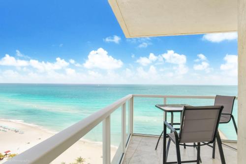 a balcony with a table and chairs and the ocean at Balcony on the Ocean - Picture Perfect in Sunny Isles Beach