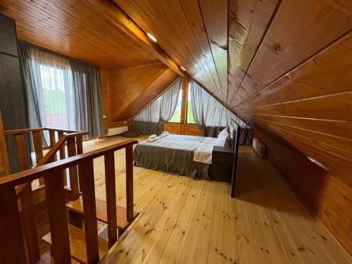 a large room with a bed in a wooden ceiling at Woodland Tskaltubo in Tskaltubo