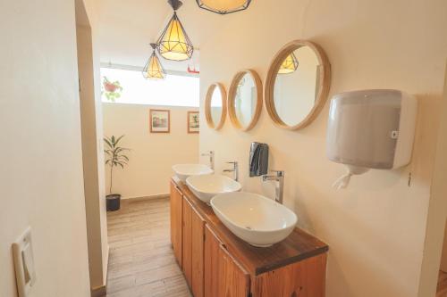 a bathroom with two sinks and two mirrors at Viajero Casco Viejo Hostel in Panama City