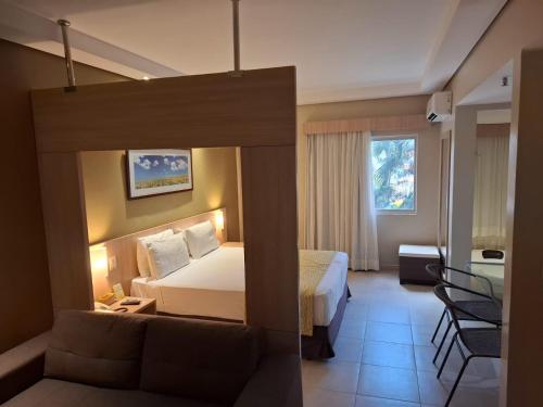a hotel room with a bed and a couch at Apartamento Suíte Flat Hot Springs Hotel em Caldas Novas com parque aquático in Caldas Novas