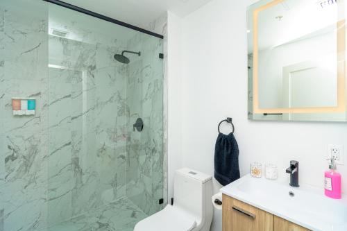 a bathroom with a shower with a toilet and a sink at MetroPark Hotel in Miami