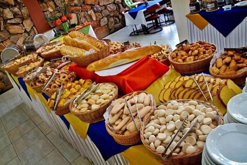 a table with baskets of different types of bread and pastries at Apartamento Suíte Flat Hot Springs Hotel em Caldas Novas com parque aquático in Caldas Novas
