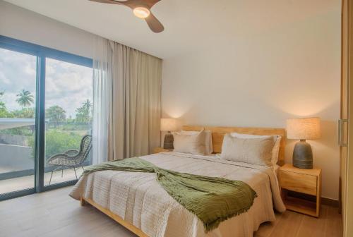 a bedroom with a bed and a large window at Sausalito | Pool View Retreat in Punta Cana
