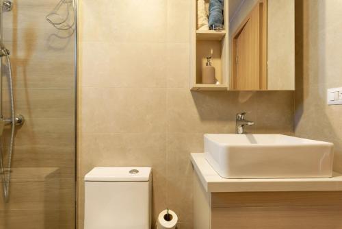 a bathroom with a toilet and a sink and a shower at Sausalito | Pool View Retreat in Punta Cana
