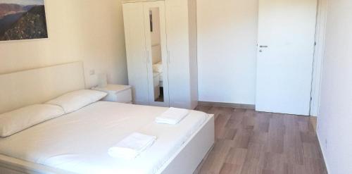 a white bed in a room with a mirror at Wellness Holiday Home in Brunate
