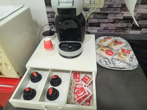 a coffee maker sitting on top of a table with donuts at Dalle ziette! in Civitavecchia