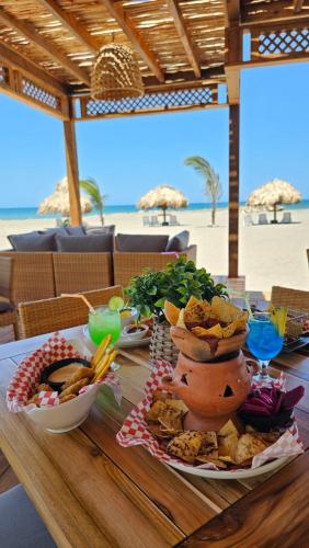 a table with plates of food on a table at the beach at Hotel Partenon Beach in La Ceiba
