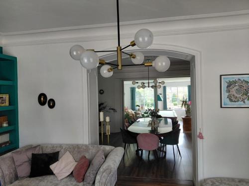 a living room with a couch and a table at Les chambres d'ACCO té in Saint-Nicolas-du-Pélem