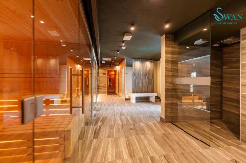 un couloir d'un immeuble avec du parquet et un banc dans l'établissement SWAN Kołobrzeg Apartament KASPROWICZA 20C BASEN, SIŁOWNIA, BAWIALNIA - wszystko w cenie, à Kołobrzeg