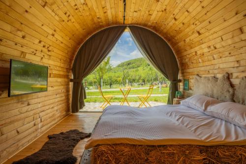 a large bed in a wooden room with a window at Kasollet e zanave in Pristina