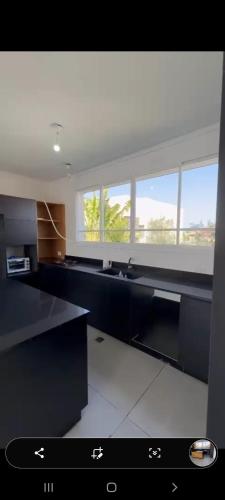 a large kitchen with black counters and windows at בריכה כחולה תחת שמיים כחולים מתאים למסיבות in Netanya