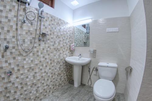 a bathroom with a toilet and a sink and a shower at Emerald Hill Bungalow in Kandy