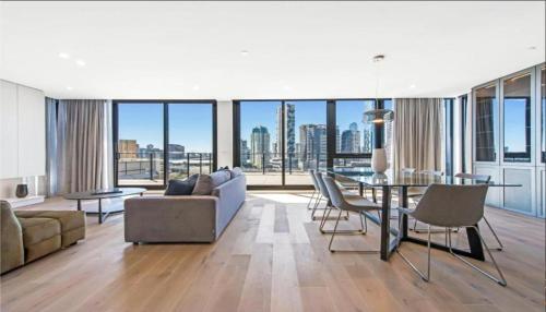 a living room with a couch and a table and chairs at Luxury Penthouse with Astonishing Bay and City Views in Melbourne