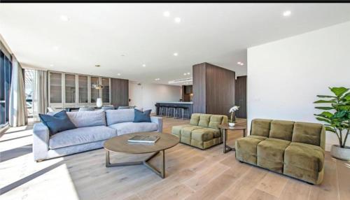a living room with a couch and two chairs and a table at Luxury Penthouse with Astonishing Bay and City Views in Melbourne