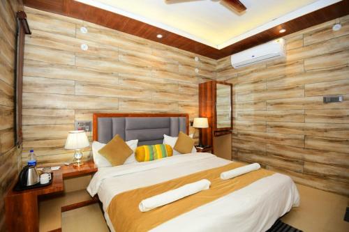 une chambre avec un lit et un mur en bois dans l'établissement A P Palace Hotel, à Ayodhya