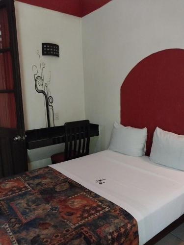 a bedroom with a large bed with a red headboard at Hotel JA CENTRO Guadalajara in Guadalajara