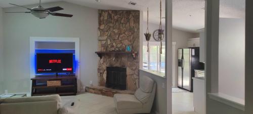 a living room with a fireplace and a tv at Entire home Private swim pool Quiet area in Jacksonville