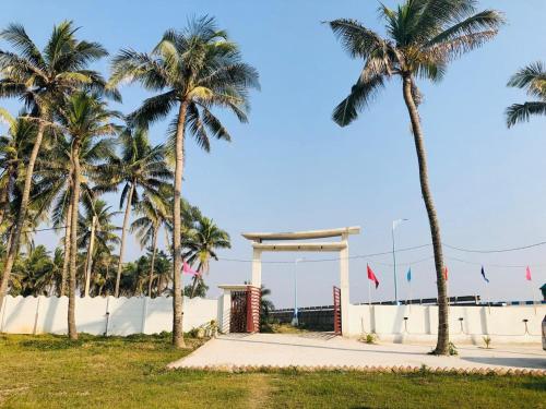 a gas station on the beach with palm trees at Home Away From Home in Tajpur