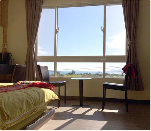 成功的住宿－巴斯拉岸民宿，一间卧室配有一张床、一张桌子和一个窗户。