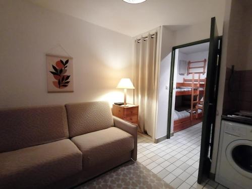 un salon avec un canapé et un miroir dans l'établissement Studio cabine - Grau du Roi, au Grau-du-Roi