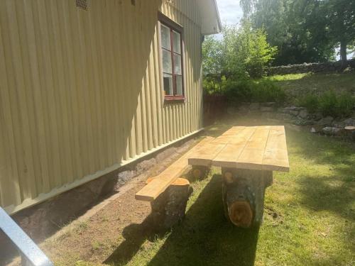 a wooden bench sitting next to a building at Hishult No 5 Hishults Prästgård in Hishult