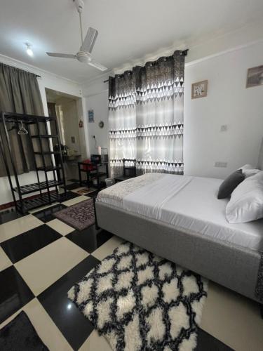 a bedroom with a bed and a black and white floor at Studio apartment Mwenge in Dar es Salaam