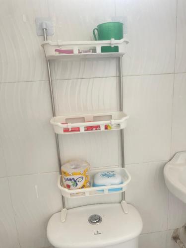 a bathroom with a white toilet in a room at Studio apartment Mwenge in Dar es Salaam