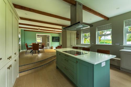 a kitchen with a green island and a dining room at Moneen Mountain View in Kinlough