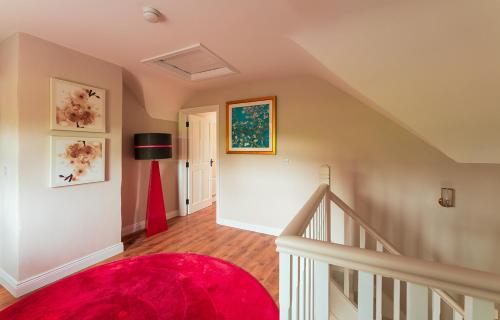 a stairway with a red rug and a red carpet at Moneen Mountain View in Kinlough