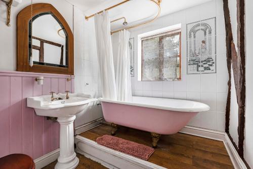 ein Badezimmer mit einer rosa Badewanne und einem Waschbecken in der Unterkunft Two Bedroom Grade ll Cottage At AZ Luxury Stays Honey Horsefield With WiFi And Free Parking in Hundon