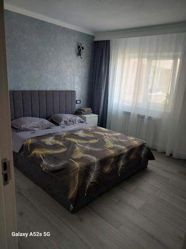 a bedroom with a bed with a gold blanket at Isabell Apartaments in Râmnicu Vâlcea